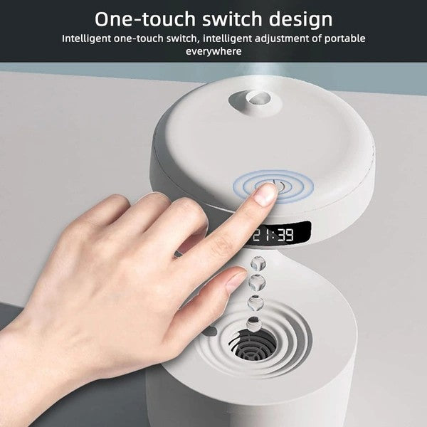 Hand pressing a one-touch switch on anti gravity humidifier with a digital display.
